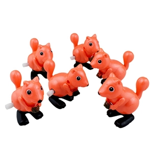Group of six wind-up orange squirrels holding pinecones with white mechanical knobs