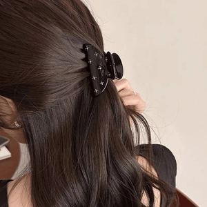 Pince à cheveux noire avec motif d'étoiles pour femmes dans une demi-coiffure