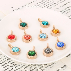 Set of ten colorful round crystal pendants with rose gold finish on white tray
