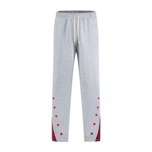 Détail du jogging gris avec imprimé à pois rouges et empiècements en tissu écossais