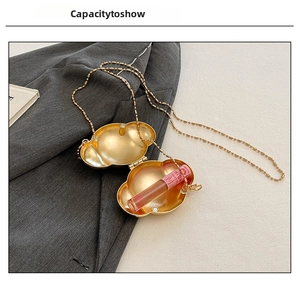 Capacity view of golden shell chain bag showing space for a lipstick inside