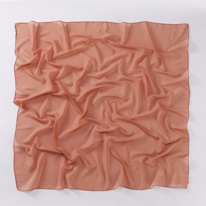 Detailed view of lightweight orange-pink chiffon square scarf with natural soft draping