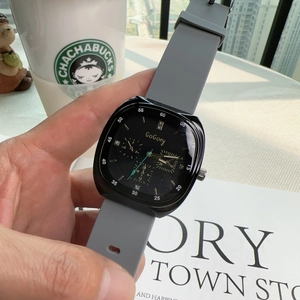 Square quartz watch with grey silicone strap and black dial shown on a female wrist