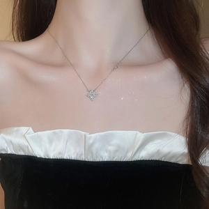 Close-up of sparkling silver starburst necklace on model's neck with zircon details