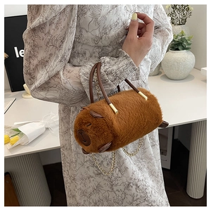 Borsa a cilindro in peluche Capybara marrone con catena dorata indossata da modella