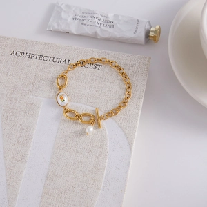 Bracelet en acier doré avec pendentif floral, perle d'eau douce et fermoir T-bar