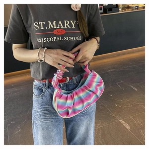 Fashionable pleated shoulder bag with rainbow gradient design shown on casual model