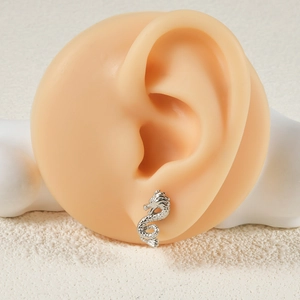 Detailed view of a silver dragon shaped threadless push-in stud on an ear model
