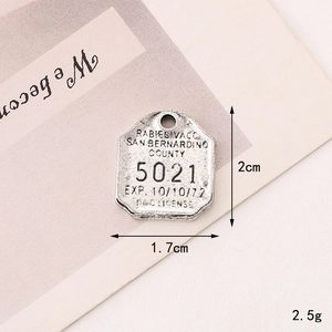 Detail view of vintage zinc alloy dog license charm with 1.7x2cm dimensions and engraved text