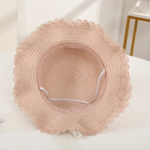 Detail of pink straw sun hat showing interior sweatband and elastic chin strap