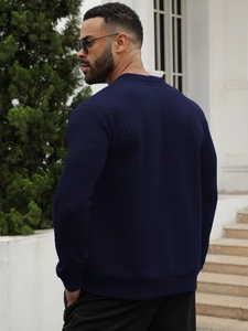 Detail of navy blue cable-knit sweater texture and ribbed cuff on a slim men's cardigan