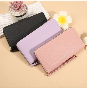 Close-up of litchi grain texture on colorful long zip wallets with matching wrist straps