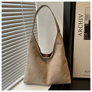 Detail of khaki suede hobo tote bag featuring a leather strap and magnetic closure