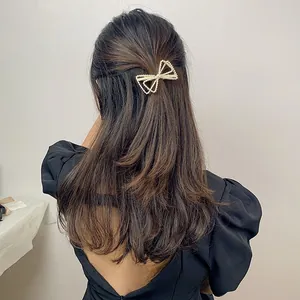 Detail of elegant pearl bow hair clip worn by model in a semi-tied hairstyle