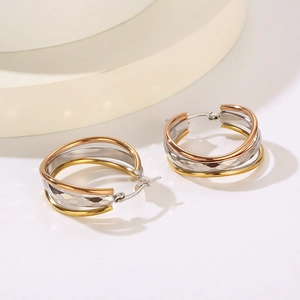 Detail of three-tone interlocking hoop earrings in gold, silver, and rose gold finish