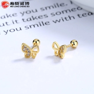 Detail of golden butterfly stud earrings with small white crystals and screw back