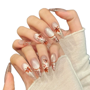 Elegant long almond cat-eye press-on nails with maple leaf and gold foil accents
