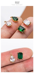 Détail de pendentifs en verre émeraude et clair avec doubles anneaux dorés pour bijoux DIY