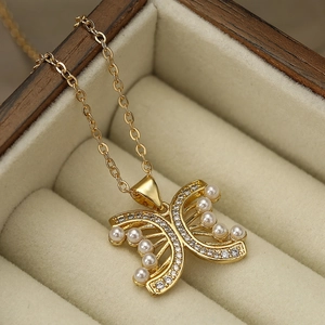 Collana a farfalla dorata con perle e zirconi presentata in una scatola portagioie