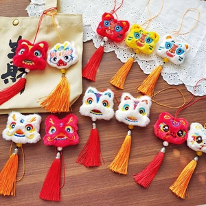 Détail du pendentif de danse du lion brodé avec pompons en soie et perles de fête