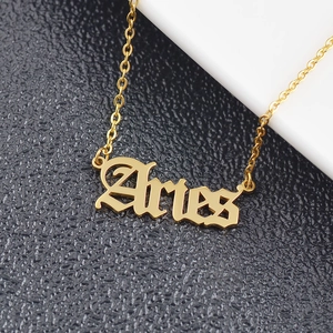 Detailed close-up of golden stainless steel Aries pendant with gothic letter design