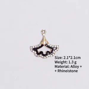 Detail of fan-shaped black enamel pendant with gold trim and white rhinestones