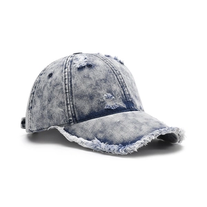 Distressed light blue wash denim baseball cap with frayed edges and ripped details