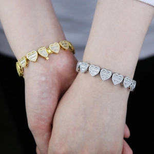 Close-up of heart-shaped link bracelets with cubic zirconia in gold and silver finish
