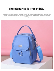 Close-up of light blue nylon mini crossbody bag showing multiple zippers and fine texture