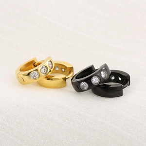 Orecchini a cerchio in titanio oro 18K e nero con tre zirconi su tessuto bianco