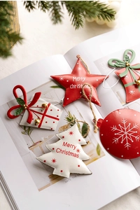 Detail of five Nordic iron Christmas ornaments including stars and bells on a magazine