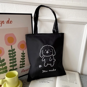 Close-up of black Oxford tote bag with white cartoon dog print and minimalist text