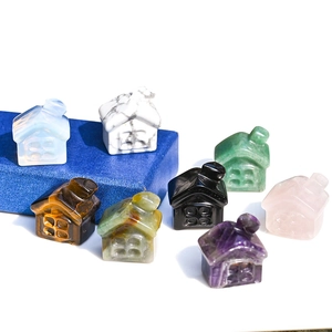 Macro display of 8 mini assorted natural crystal house carvings on a blue box