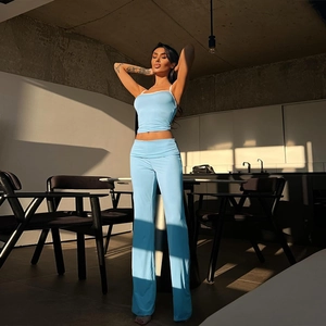 Dettaglio del crop top in pizzo celeste e del set pantaloni a gamba larga a vita alta chic