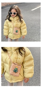 Close-up of yellow glossy kids down jacket with a brown knitted Christmas tree bag