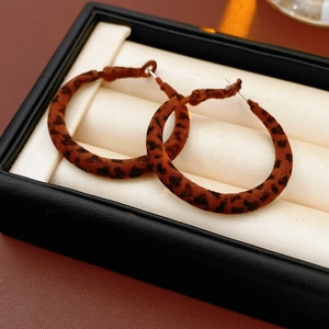 Vue détaillée des boucles d'oreilles léopard rondes vintage avec texture velours marron