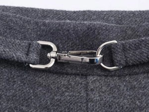 Detailed close-up of dark grey twill fabric texture and silver metal buckle fastener