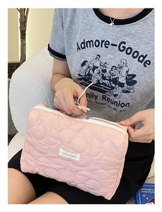Détail de la trousse de maquillage rose matelassée avec couture nuage et fermeture éclair