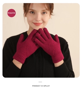 Close-up detail of dark red knitted winter gloves with thick thermal texture and patterns