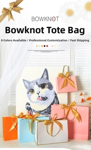 Detail of colorful gift bags with golden satin bowknots and woven rope handles