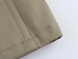 Dettaglio macro del tessuto twill kaki con cuciture a doppio ago di alta qualità