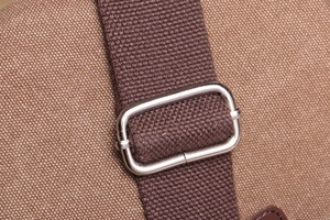 Detail of brown canvas texture with adjustable metal buckle and durable woven strap