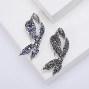 Detail view of bow ribbon brooches with purple blue and black rhinestones in silver alloy
