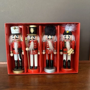 Detail of four handcrafted wooden nutcracker soldier figurines in a red gift box