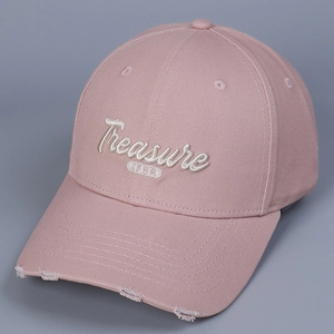 Close-up of pink baseball cap with white Treasure embroidery and vintage distressed details