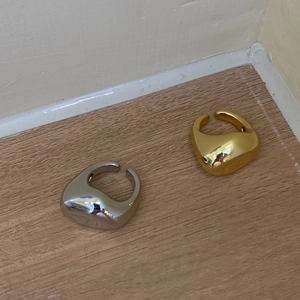 Toma macro de anillos de oro y plata pulidos con diseño de textura de metal líquido