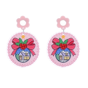 Detail of pink and red Christmas acrylic earrings featuring bow and snow house patterns