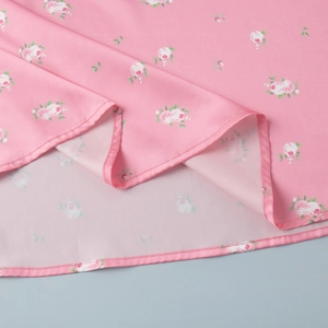 Detailed close-up of pink rose floral print fabric with high-quality hem stitching
