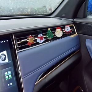 Close-up of five Christmas car air freshener clips on the air vent with Santa and Reindeer