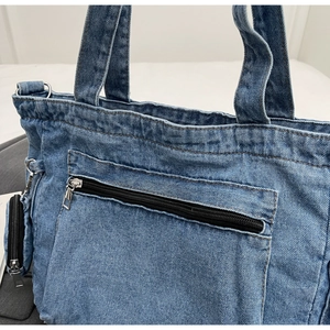 Detail of blue denim tote bag with zipper pocket, double handles and small pouch